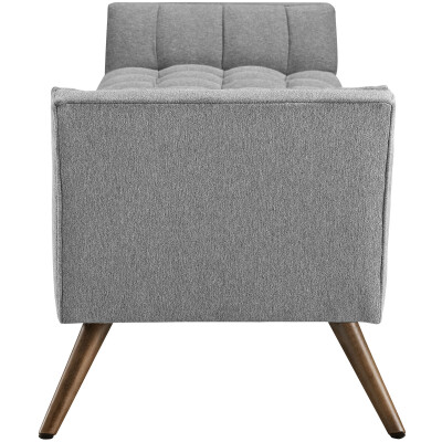 A gray upholstered bench with wooden legs.